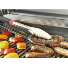 Grillzange hält Wurst über Grillrost