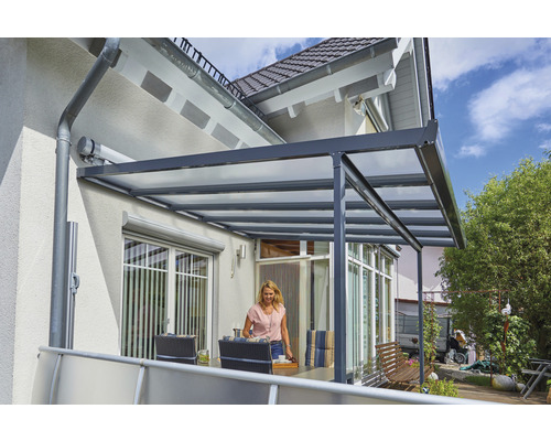 Terrassenüberdachung aus Aluminium und Kunststoff mit Frau im Außenbereich.