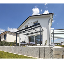 Terrasse mit Terrassenüberdachung, Grill und Sitzgruppe vor einem Haus