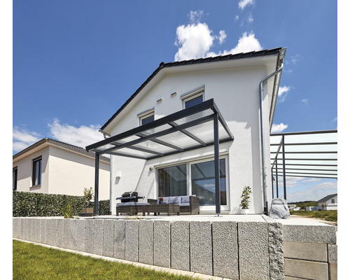 Terrasse mit Terrassenüberdachung, Grill und Sitzgruppe vor einem Haus