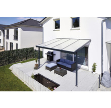 Terrasse mit Terrassenüberdachung, Grill und Gartenmöbeln vor einem Wohnhaus