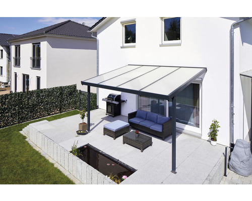 Terrasse mit Terrassenüberdachung, Grill und Gartenmöbeln vor einem Wohnhaus