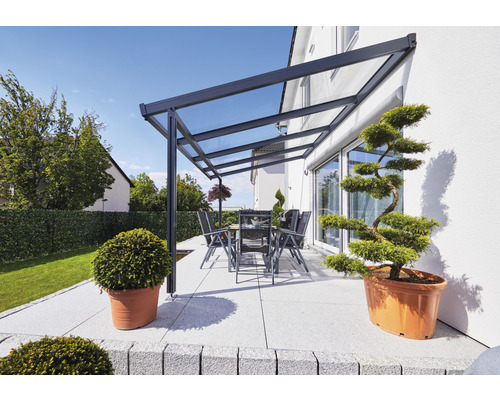 Terrasse mit Terrassenüberdachung, Tisch und Stühlen sowie dekorativen Pflanzen