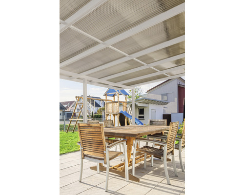 Terrassenüberdachung mit Gartenmöbeln und Spielplatz im Hintergrund