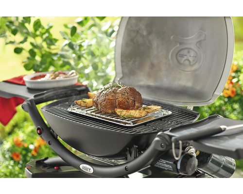Grill mit Braten und Kartoffeln im Freien