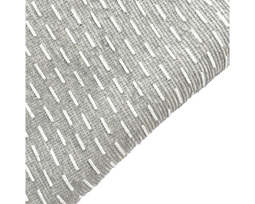 Detailansicht eines grauen Teppichs mit weißen Zierstichen