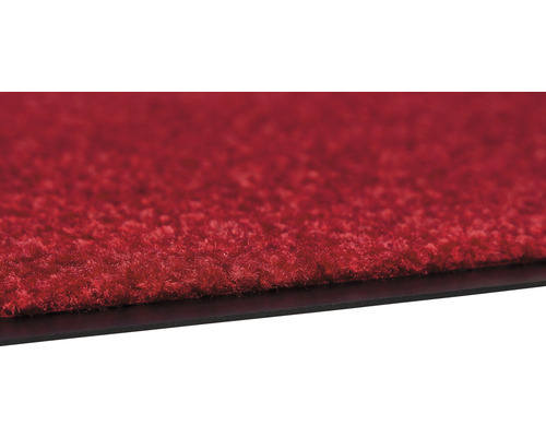 Detailansicht einer roten Teppichfliese mit schwarzer Unterseite.
