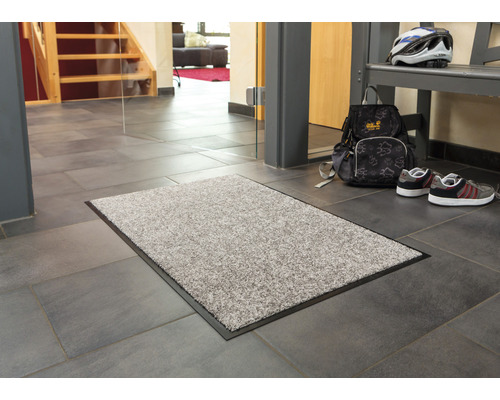 Fußmatte im Eingangsbereich eines Hauses auf Fliesenboden