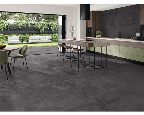 Helle Küche mit Esstisch, Küchenzeile und großen, dunklen Bodenfliesen.