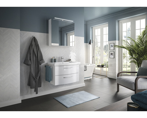 Helles Badezimmer mit Waschtisch, Spiegelschrank und Badewanne.