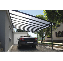 Carport mit Stahlrahmen und transparentem Dach neben einem Haus mit Garage