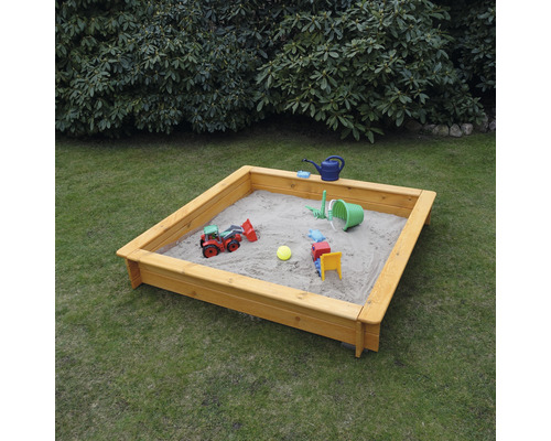 Quadratischer Sandkasten aus Holz mit Spielzeug auf einer Rasenfläche