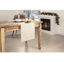 Esstisch mit Tischläufer, Geschirr und Dekoration vor einem Kamin