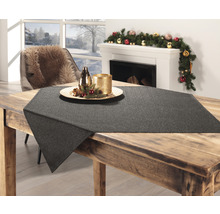 Dekoratives Arrangement mit Tischläufer, Kerzen und saisonaler Dekoration auf einem Holztisch in einem hellen Wohnzimmer.