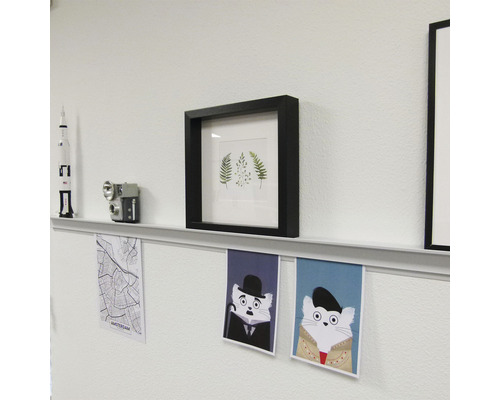 Wanddekoration mit Bilderrahmen, Regalboden und Postern