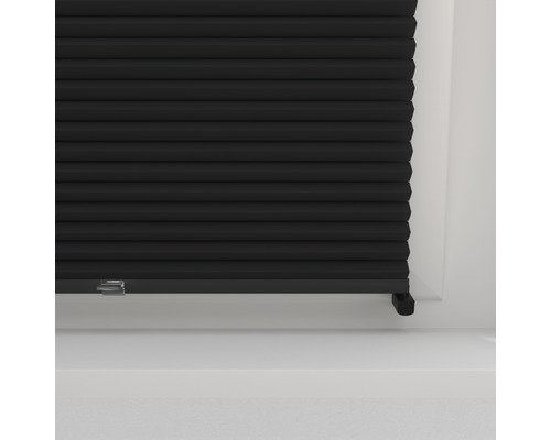 Nahaufnahme einer schwarzen Plisseejalousie am Fenster