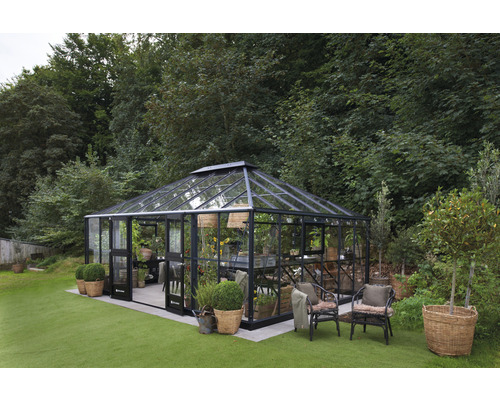 Gewächshaus im Garten mit Pflanzen und Gartenmöbeln