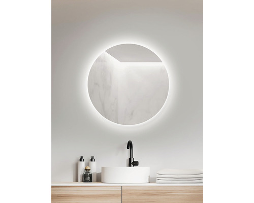 Badezimmer mit rundem Spiegel, Waschtisch und Armatur