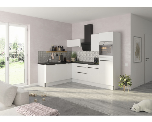 Helle Küche mit weißen Schränken, Dunstabzugshaube und Spüle vor gemusterter Rückwand