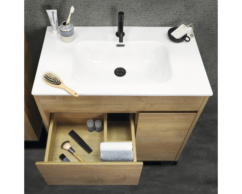 Waschtischunterschrank aus Holz mit geöffneter Schublade und diversen Badartikeln auf der Oberfläche