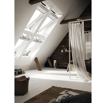 Helles Schlafzimmer im Dachgeschoss mit Dachfenstern und Holzbalken