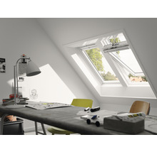 Dachzimmer mit Dachfenster und Schreibtisch mit Arbeitsmaterialien