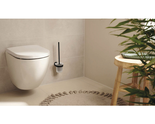 Hänge-WC mit Toilettenbürste und Hocker in einem hellen Badezimmer