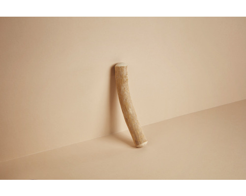 Einzelner Holzstab lehnt an der Wand