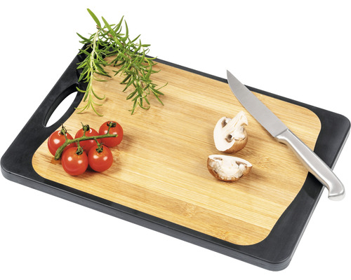 Schneidebrett aus Bambus mit Tomaten, Pilzen, Rosmarin und Messer