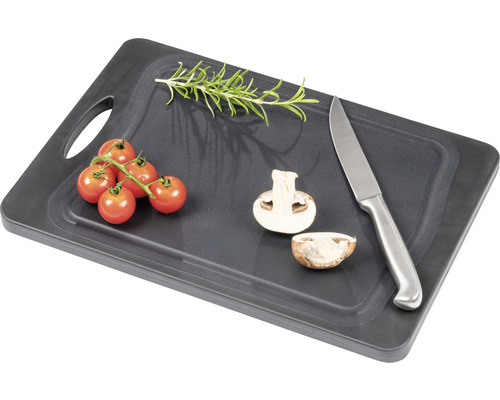 Dunkles Schneidebrett mit Tomaten, Champignons, Rosmarin und Messer
