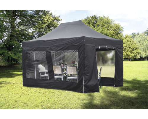 Faltpavillon bellavista - Home & Garden® 4,5 x 3 x 3,40 m rechteckig schwarz Schwarzer Faltpavillon mit Fenstern und Gartenmöbeln auf einer Rasenfläche.