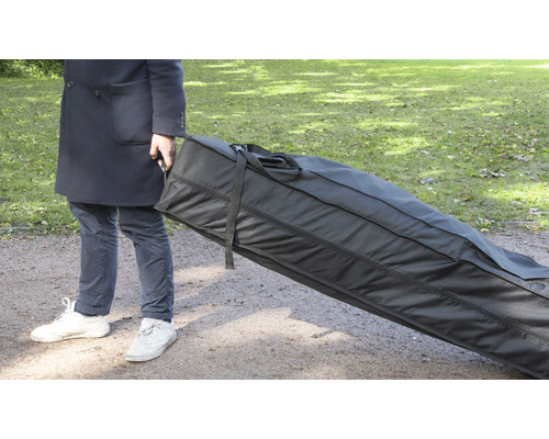 Person transportiert eine grosse schwarze Tragetasche im Freien.