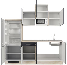 Küchenzeile mit Kühlschrank, Mikrowelle, Spüle und offenen Schränken.