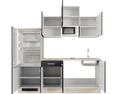 Küchenzeile mit Kühlschrank, Mikrowelle, Spüle und offenen Schränken.