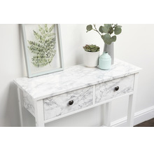 Dekoratives Arrangement auf einem weißen Konsolentisch mit Schubladen und Marmorfolie