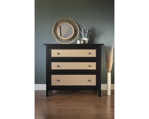 Kommode mit drei Schubladen aus Holz und Rattangeflecht vor einer Wand mit Spiegel und Dekoration.
