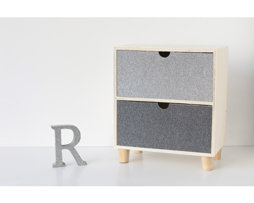 Kleiner Schrank mit zwei Schubladen und Holzbeinen neben einem grauen Buchstaben R.