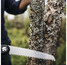 Nahaufnahme einer Handsäge beim Sägen eines Astes