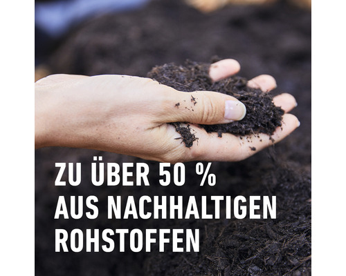 Eine Hand hält Blumenerde. Die Blumenerde besteht zu über 50 Prozent aus nachhaltigen Rohstoffen.