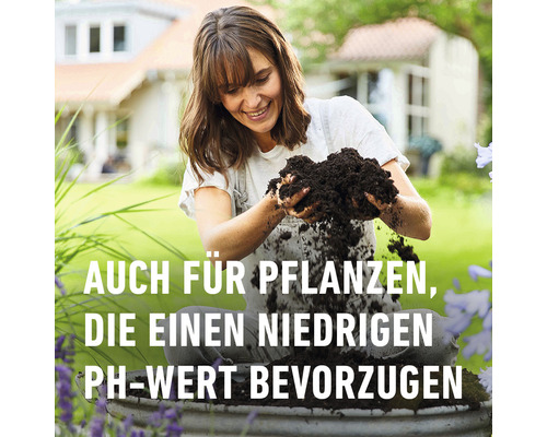 Frau hält Blumenerde in den Händen, geeignet für Pflanzen, die einen niedrigen pH-Wert bevorzugen.