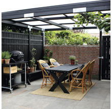 Überdachte Terrasse mit Esstisch, Korbstühlen, Grillwagen und Zaun