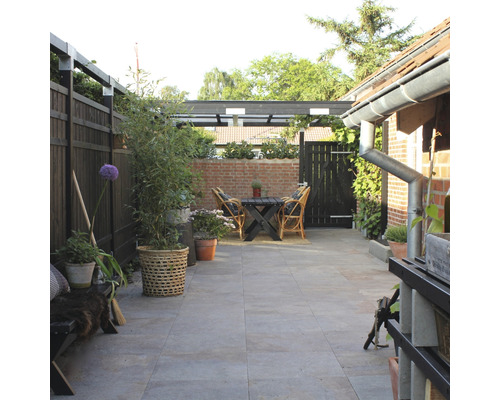 Garten mit Terrasse, Tisch, Stühlen, Zaun und Pflanzen