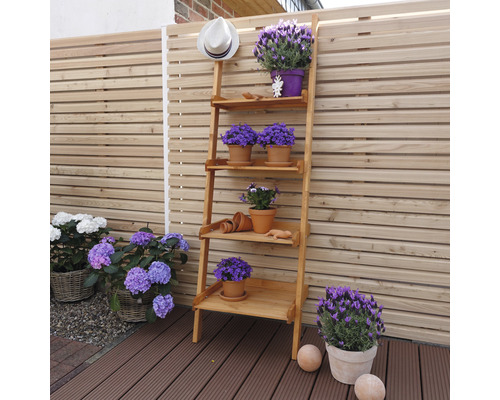 Holzregal mit Blumen und Gartendekoration im Außenbereich