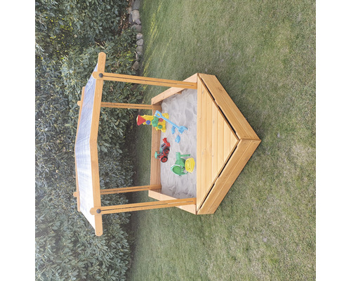 Sandkasten aus Holz mit Spielzeug im Garten