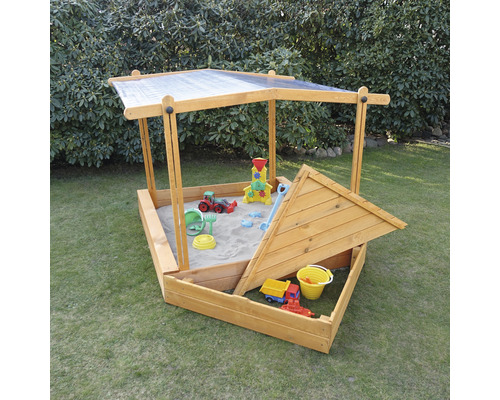 Sandkasten aus Holz mit Dach und Sandspielzeug im Garten