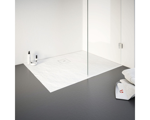 Ebenerdige Dusche mit Duschwanne aus Steinzeug und Duschabtrennung aus Glas in einem hellen Badezimmer.