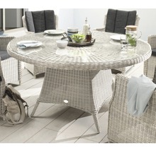 Runder Gartentisch mit Glasplatte und Korbsessel für den Außenbereich