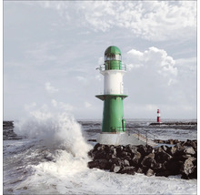 Grüner Leuchtturm an der Küste mit Wellen