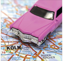 Rosa Spielzeugauto auf einer Straßenkarte von Köln