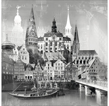 Schwarzweiß-Fotografie von Lüneburg mit Gebäuden, Kirchtürmen, Brücke und Fluss.